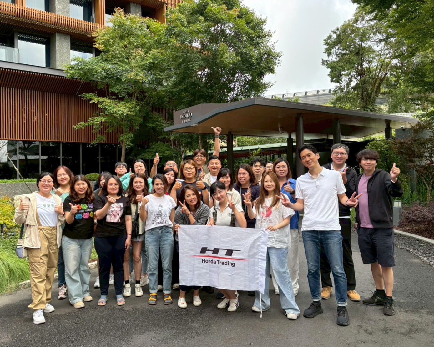 台湾の2拠点合同の社員旅行で撮影された集合写真。HT Honda Tradingのバナーを掲げた参加者たち。